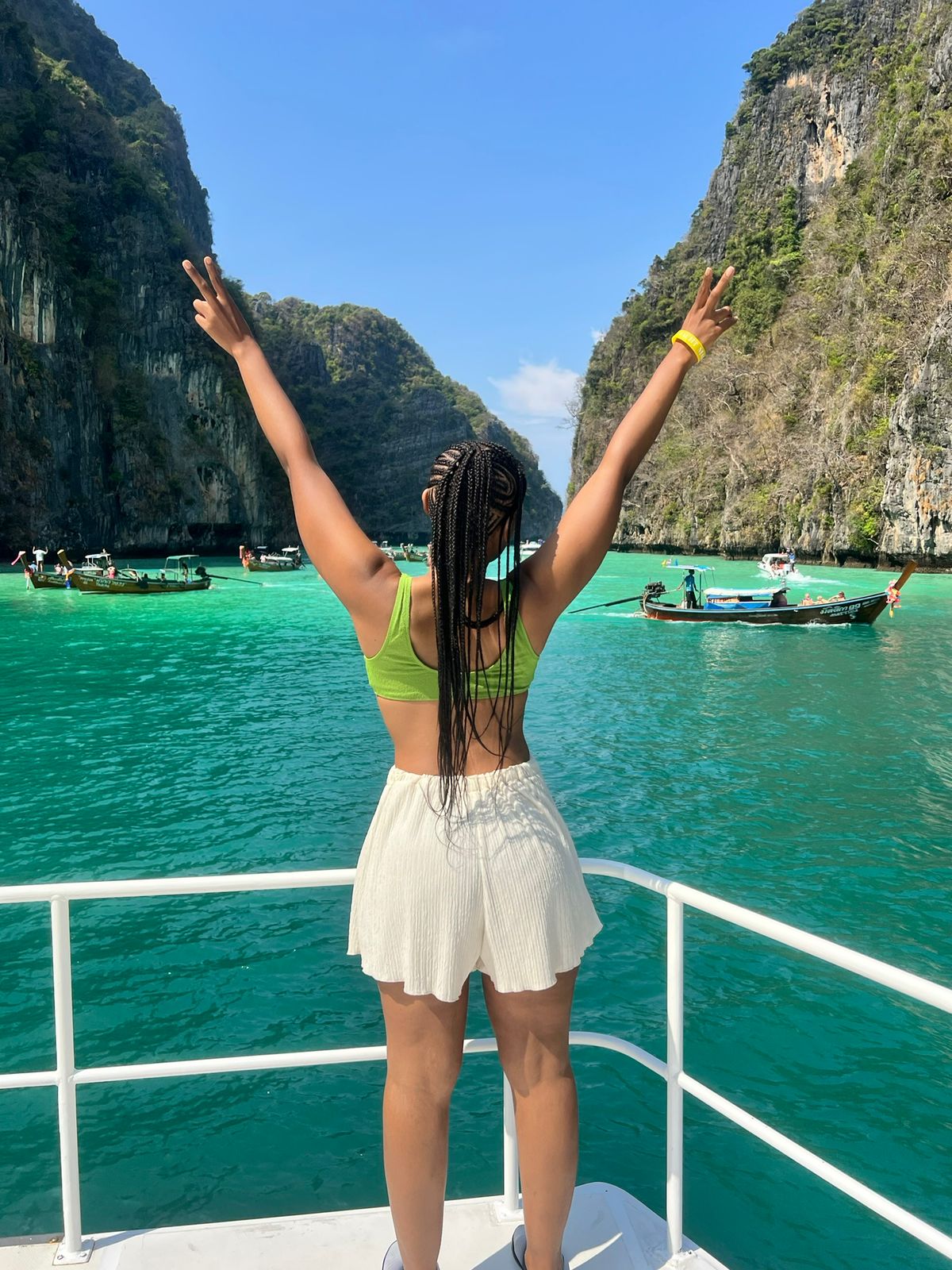 Sisters celebrating on a boat in the turquoise waters of Phi Phi Islands, Thailand
